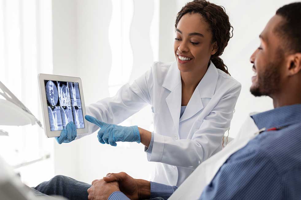 Dentist showing patient X Rays of Mouth