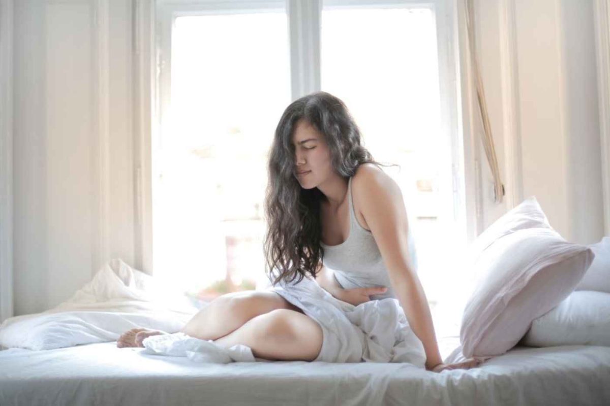 Woman in bed holding her stomach