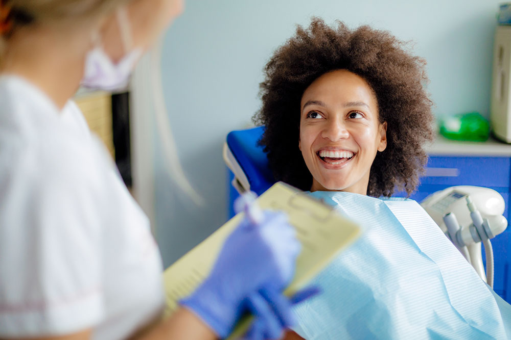 Woman in dental chair, smiling at the dentist