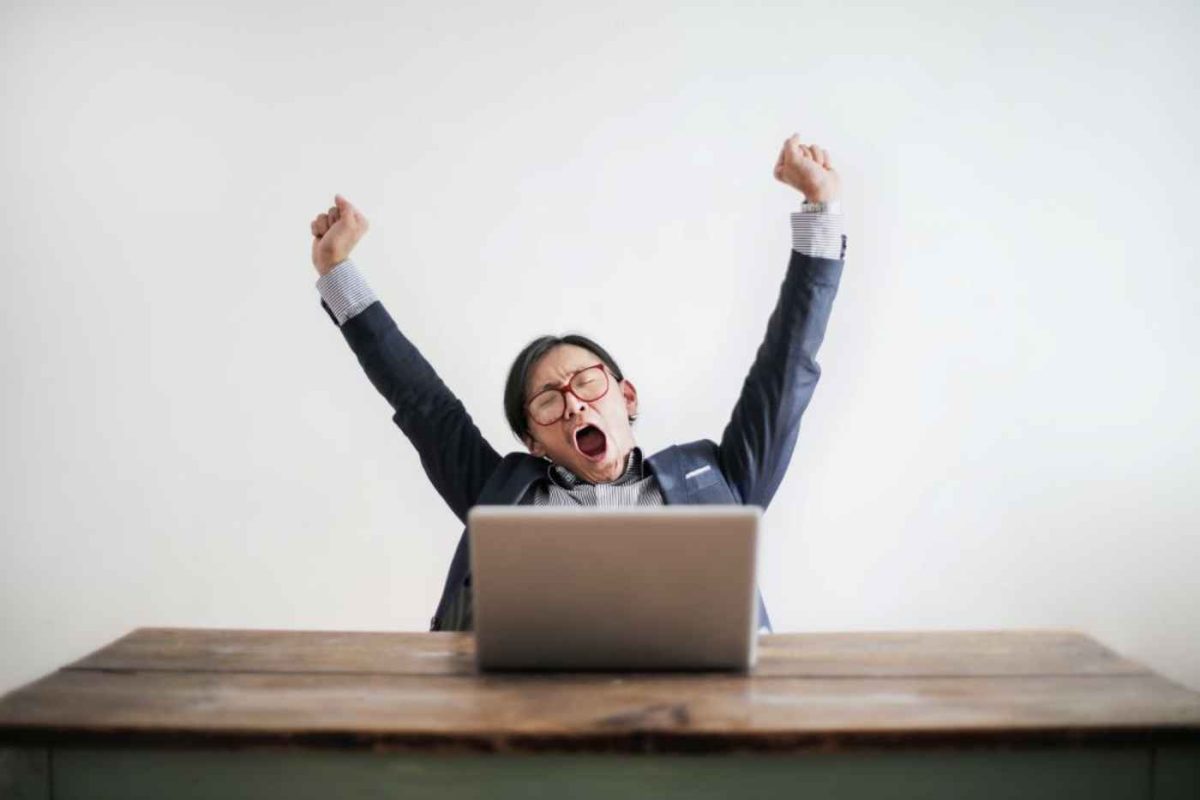 Woman in front of laptop yawning